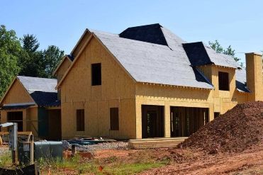 A house that is being built with a pile of dirt in front of it