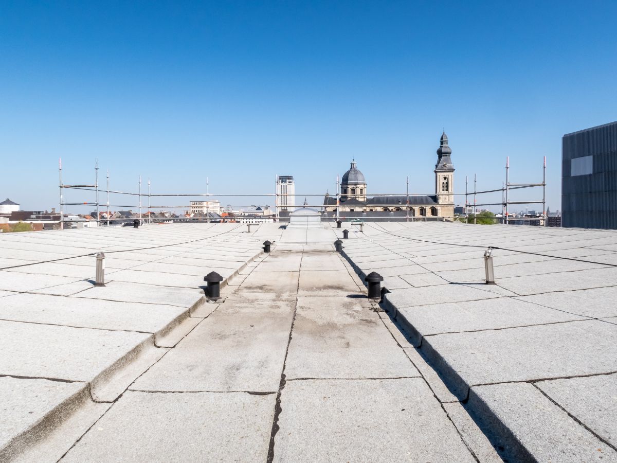 Rooftop view with a church, blue sky, and a building under construction.