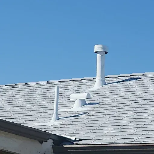 White roof with vents against a bright blue sky.