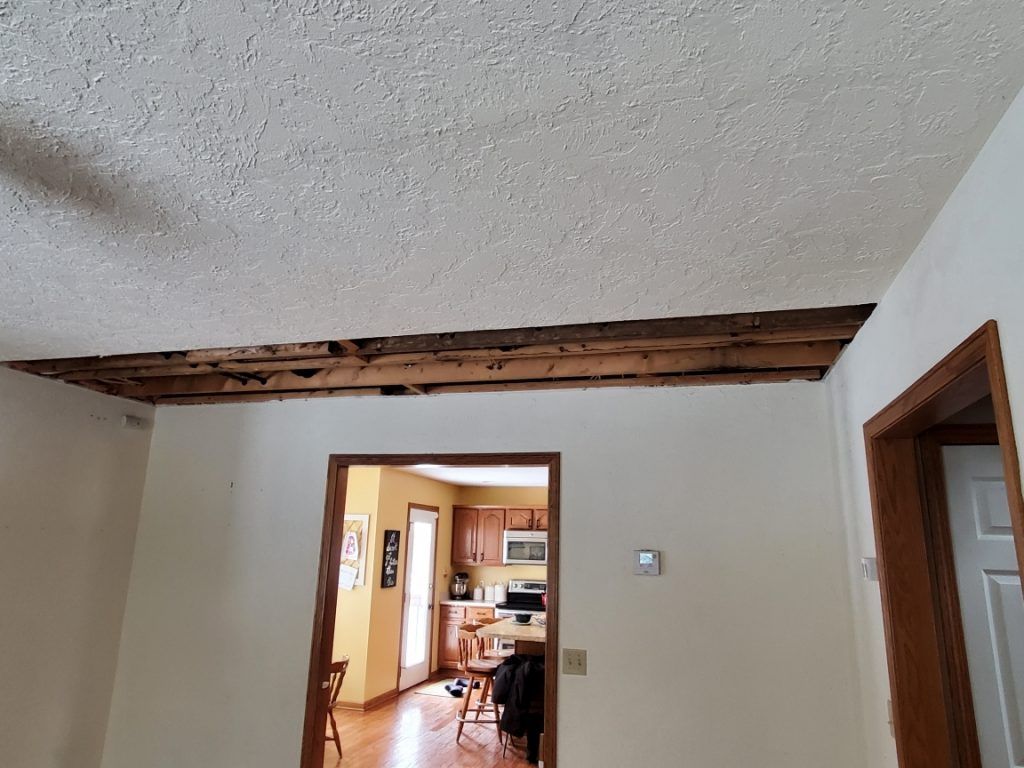 A room with a ceiling that is missing a wooden beams.