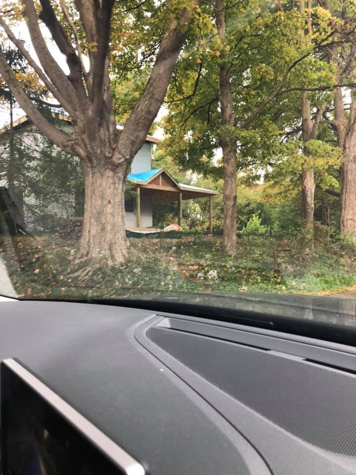 A view of a house through the windshield of a car.