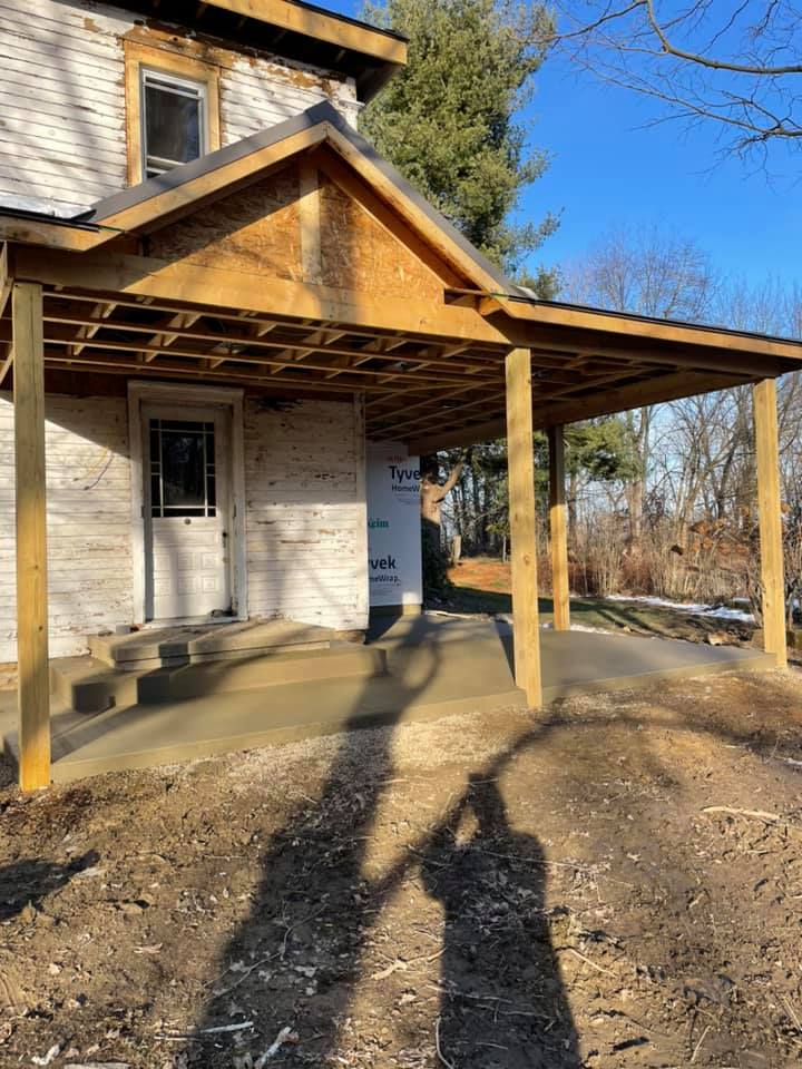 A wooden porch is being built on the side of a house.