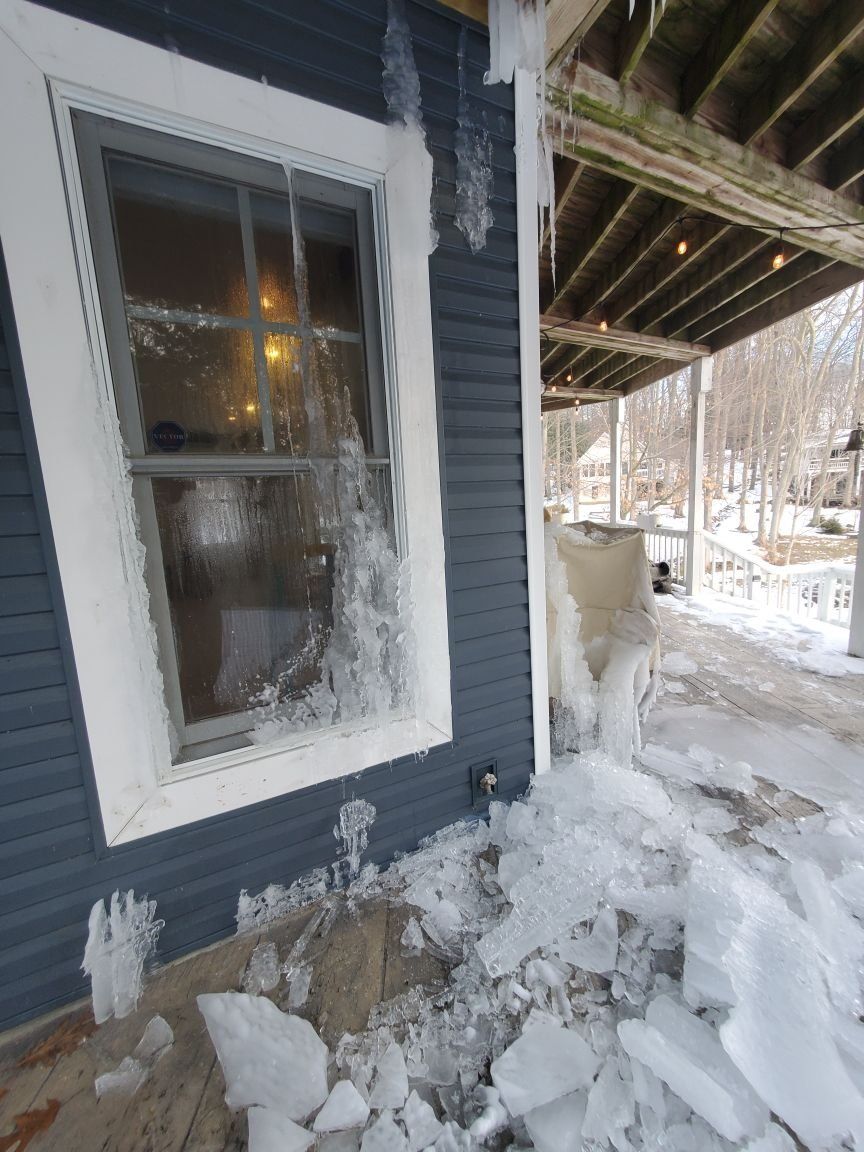 A house with a window that is covered in snow and ice. 
