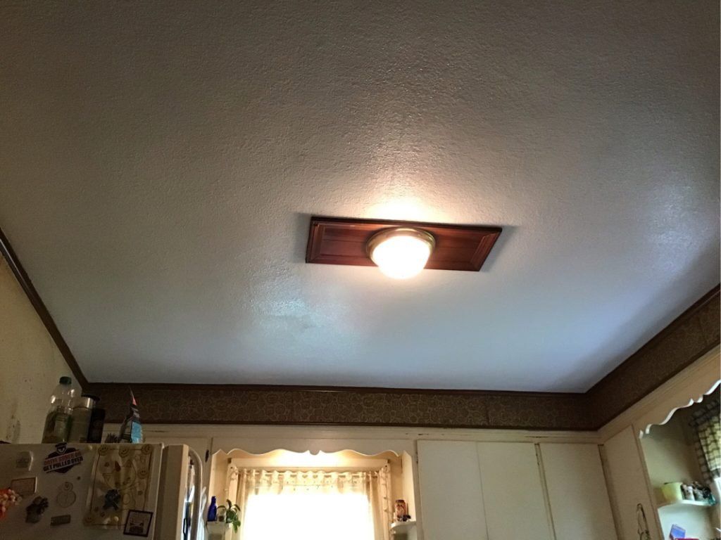 A kitchen with a light hanging on the ceiling.