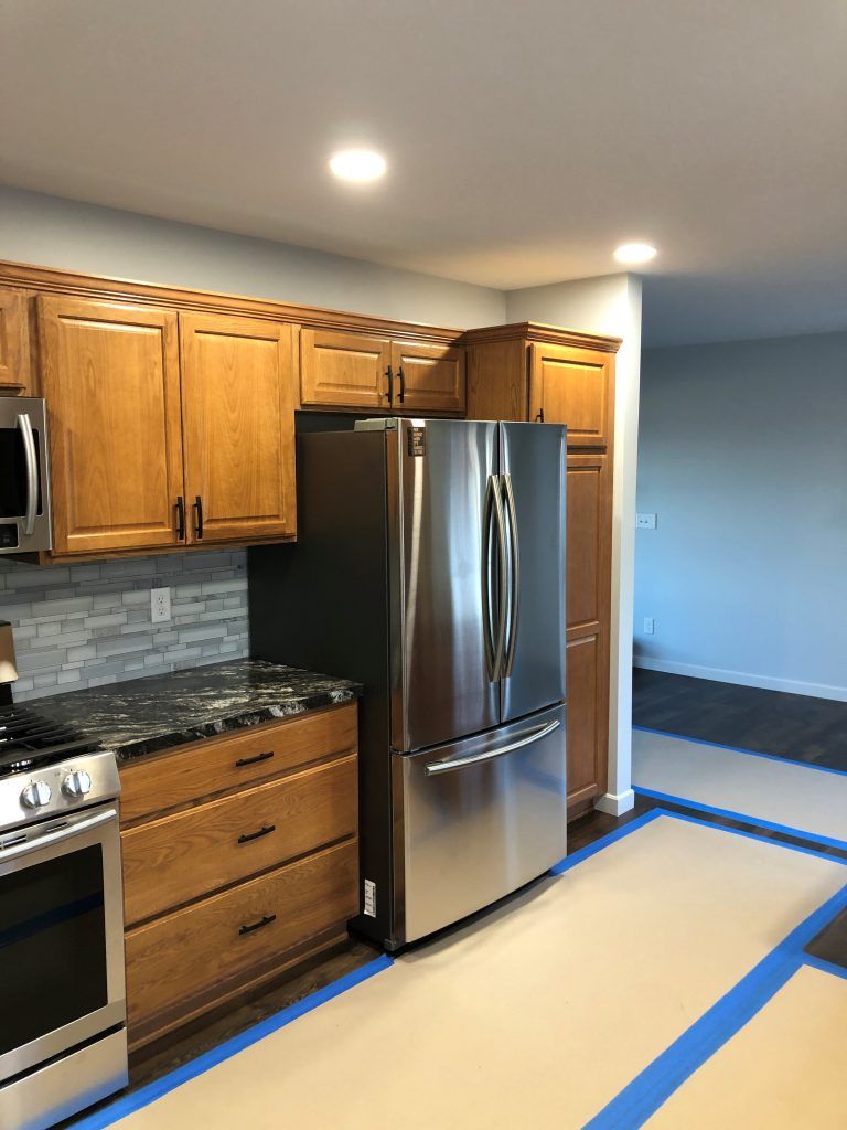 A kitchen with stainless steel appliances and wooden cabinets.
