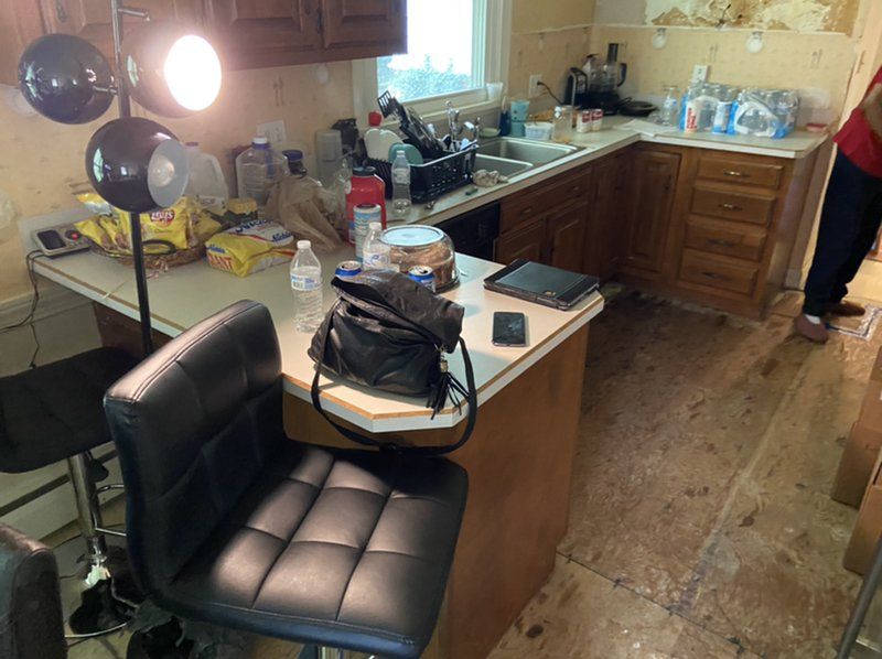 A kitchen with a chair and a lamp on the counter.