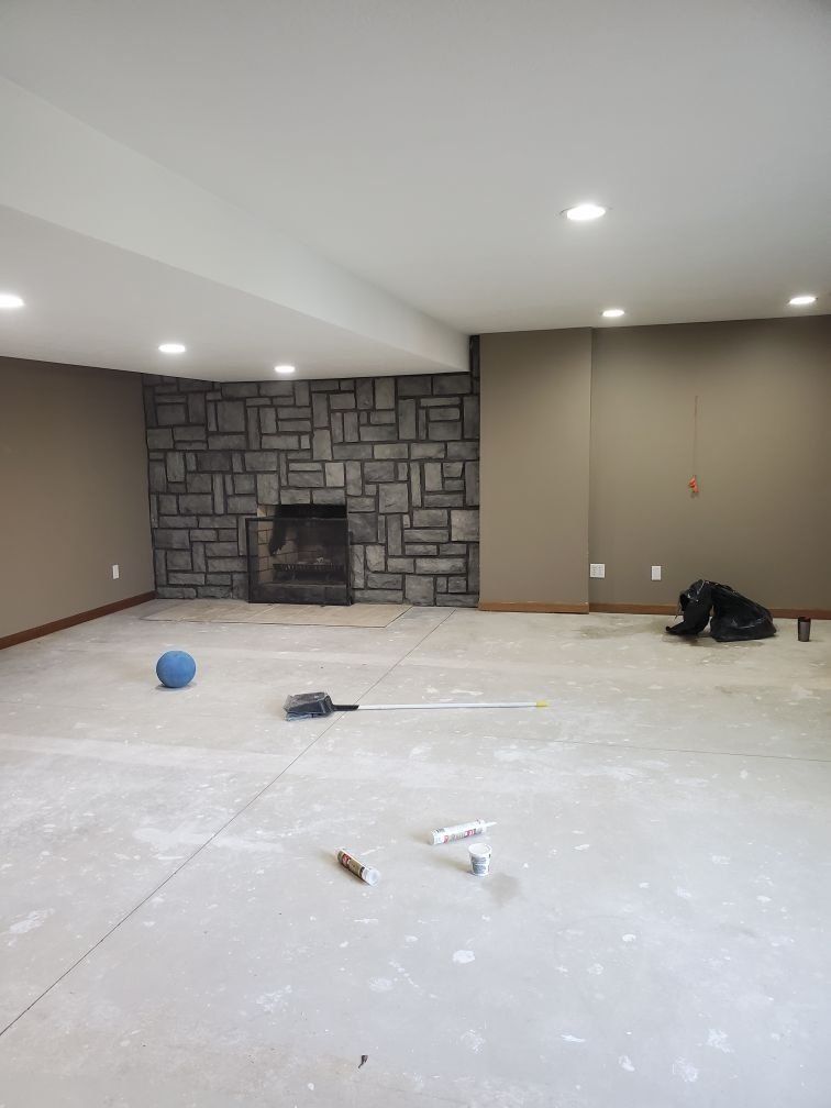 An empty room with a fireplace and a brick wall.