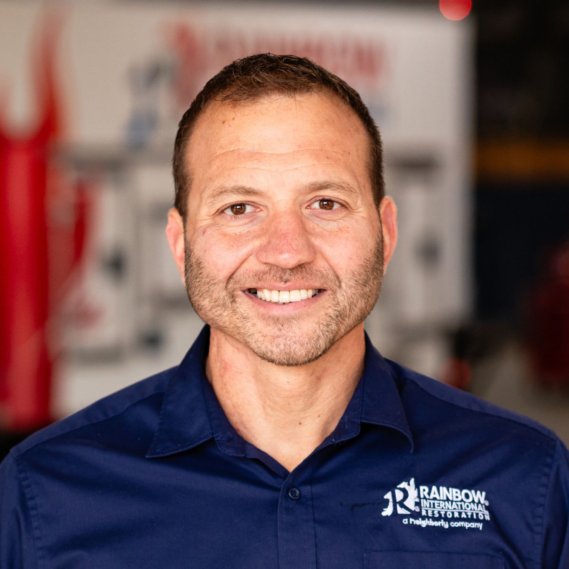 A man in a blue shirt is smiling for the camera.
