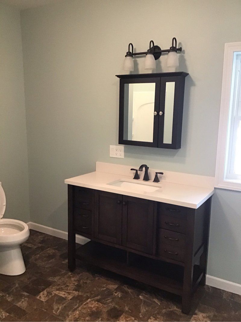 A bathroom with a sink , toilet and mirror.