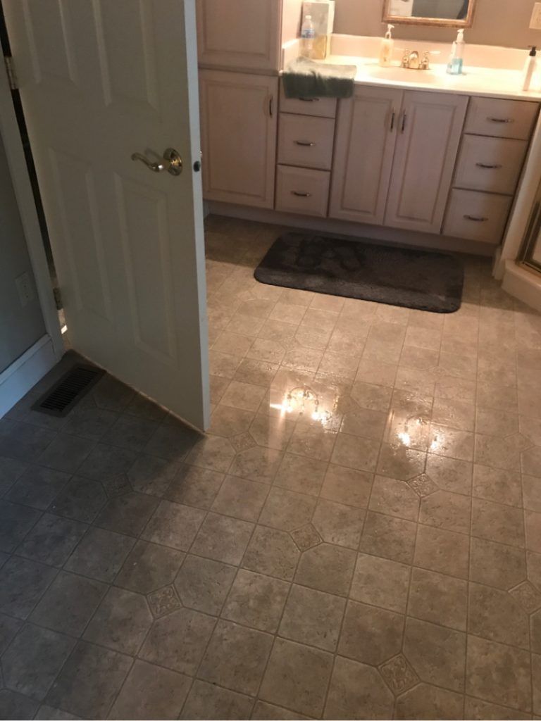A bathroom with a sink, cabinets, and a door.