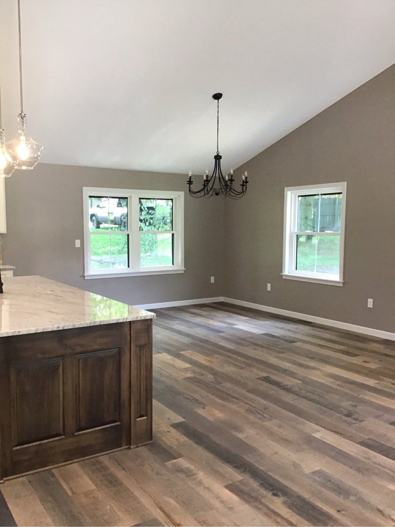 A dining room with hardwood floors and a chandelier hanging from the ceiling.