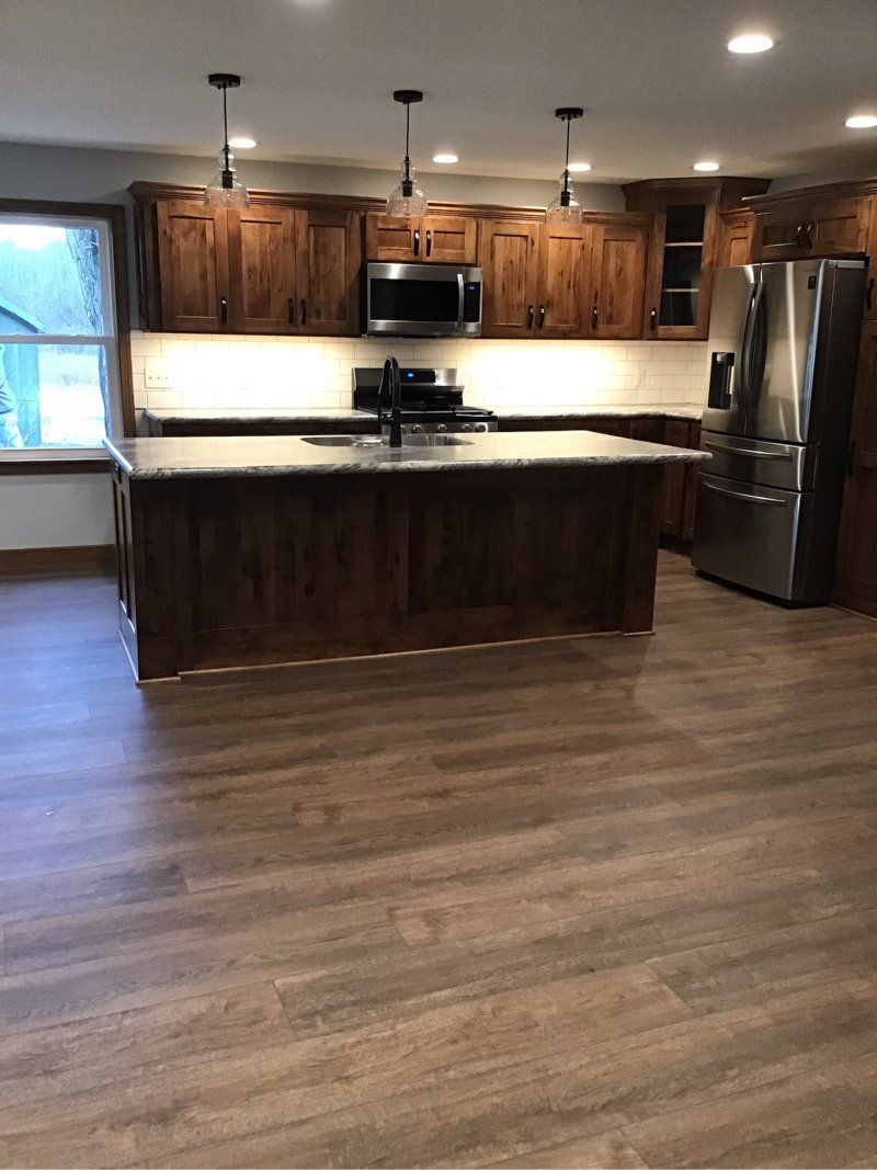 A kitchen with stainless steel appliances and wooden cabinets.