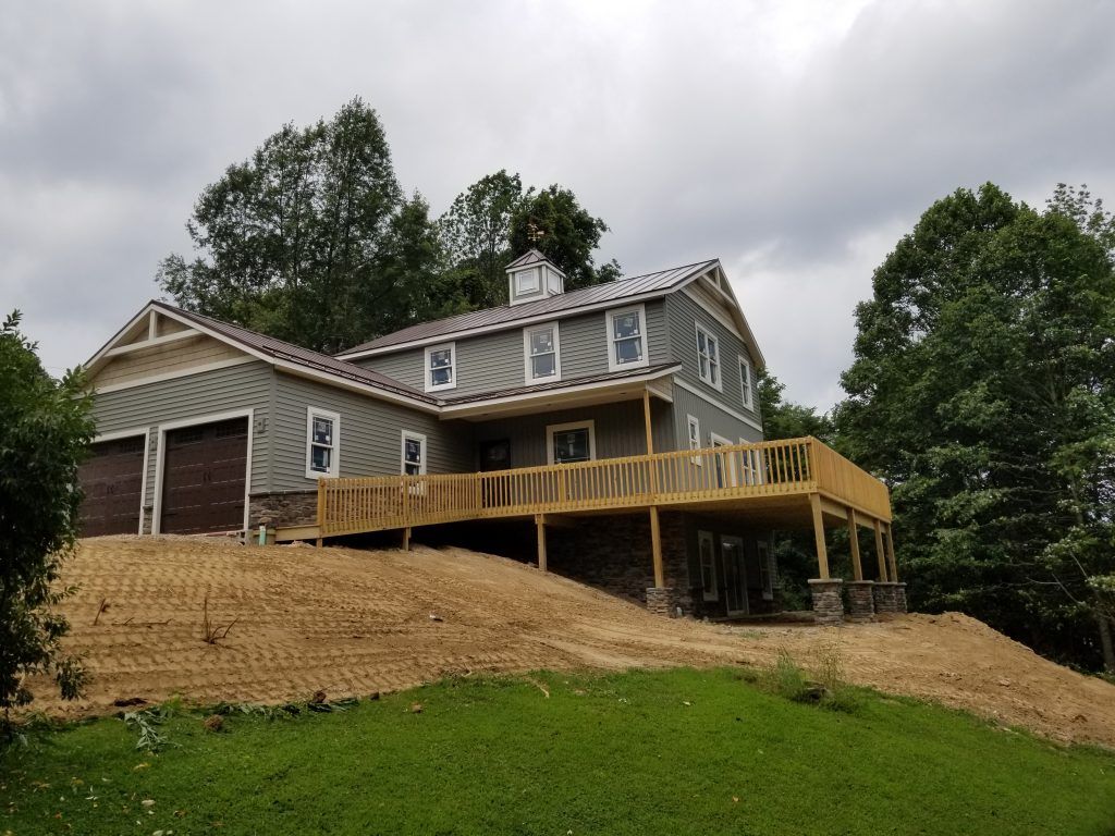 A large house with a large deck and a garage.