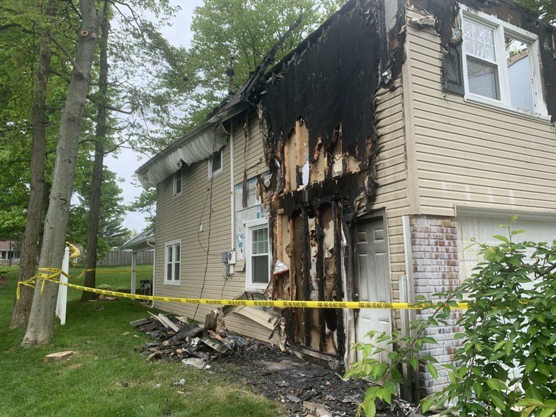 A house that has been damaged by a fire is surrounded by yellow tape.