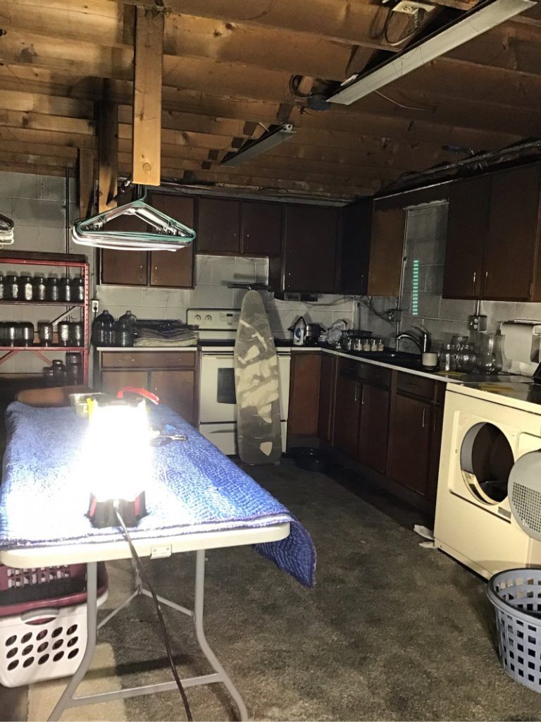 A kitchen with a table , stove , washer and dryer.