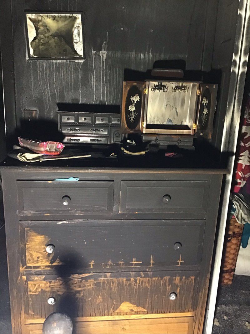 A dresser with smoke and fire damage.