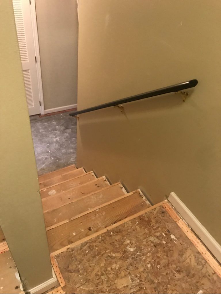 A wooden staircase with a hand rail in a house.