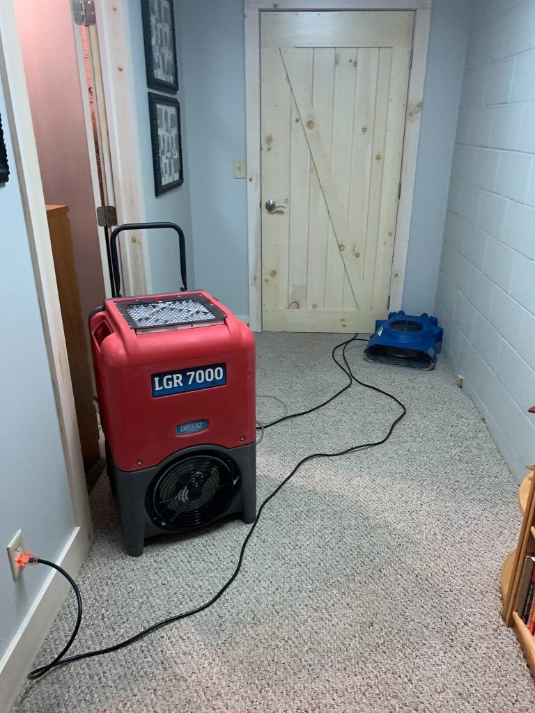 Big fans set up in the hallway of the basement in this house.