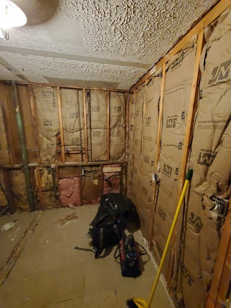 A room with a lot of insulation on the walls and a broom.