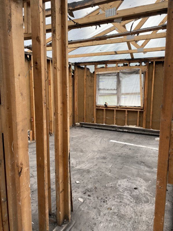 A house is being built with wooden beams and a window.