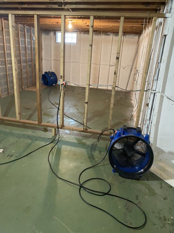 2 Big blue fans set up to dry out the basement.