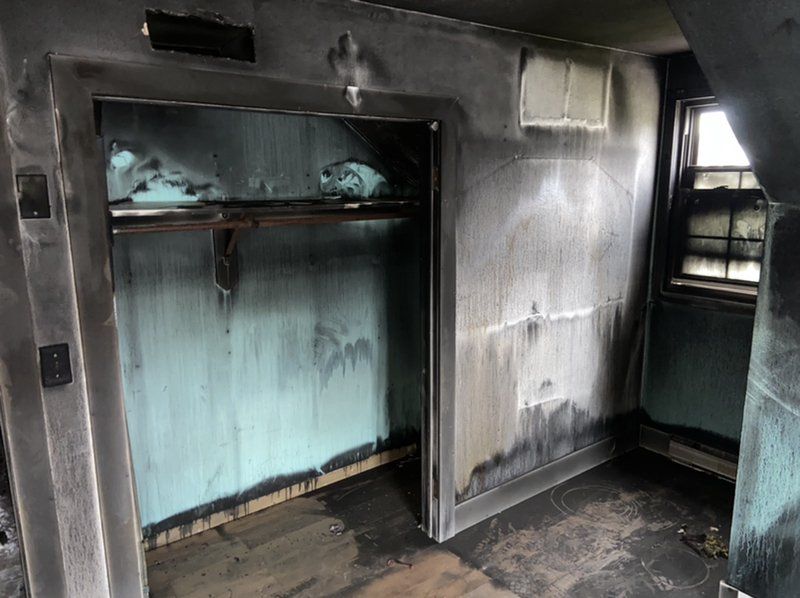 A room with a closet that has been damaged by fire.