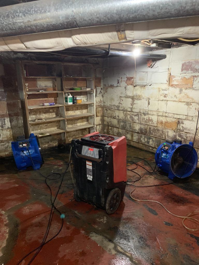 Three fans strategically set up to dry out the affected area.