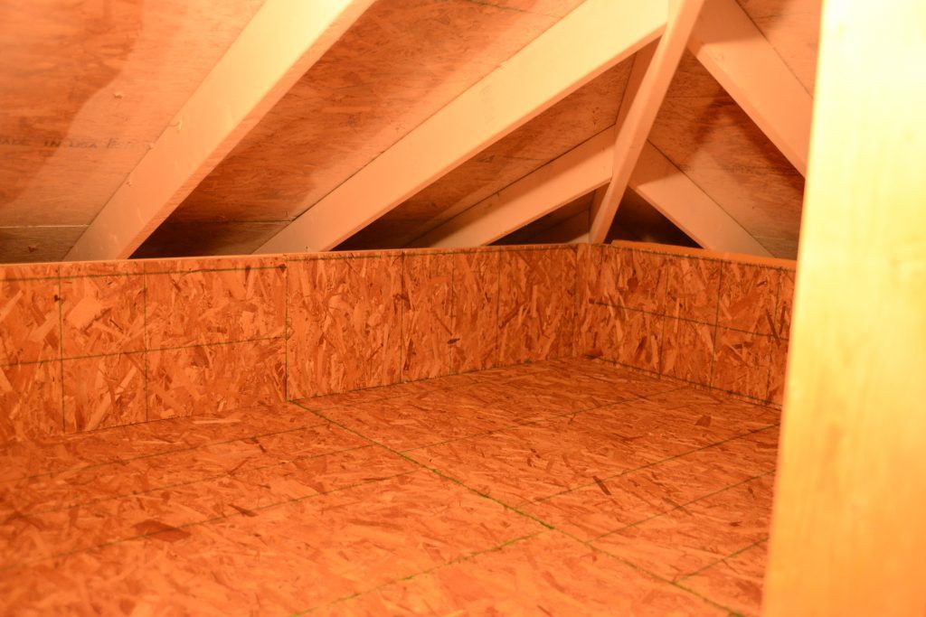 An attic with a wooden ceiling and a wooden floor.