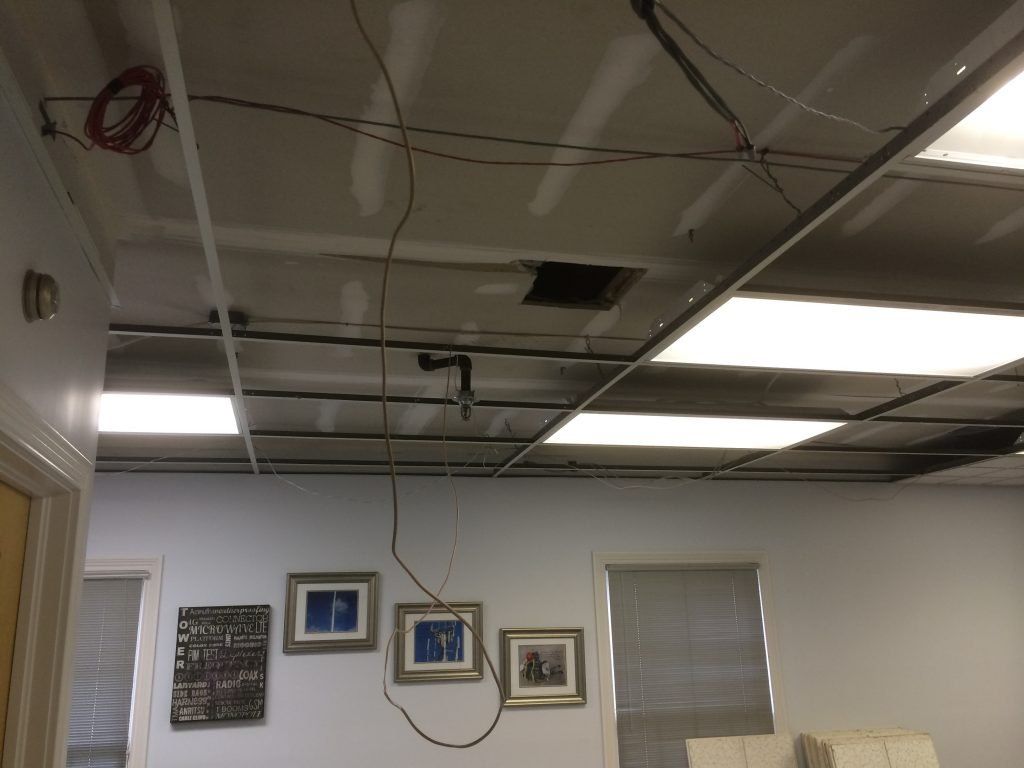 A ceiling with a lot of wires hanging down from it.