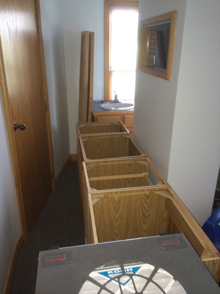 A hallway with wooden cabinets and a box on the floor.