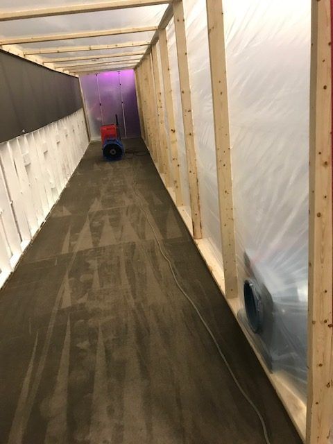A long hallway covered in plastic and wooden beams.
