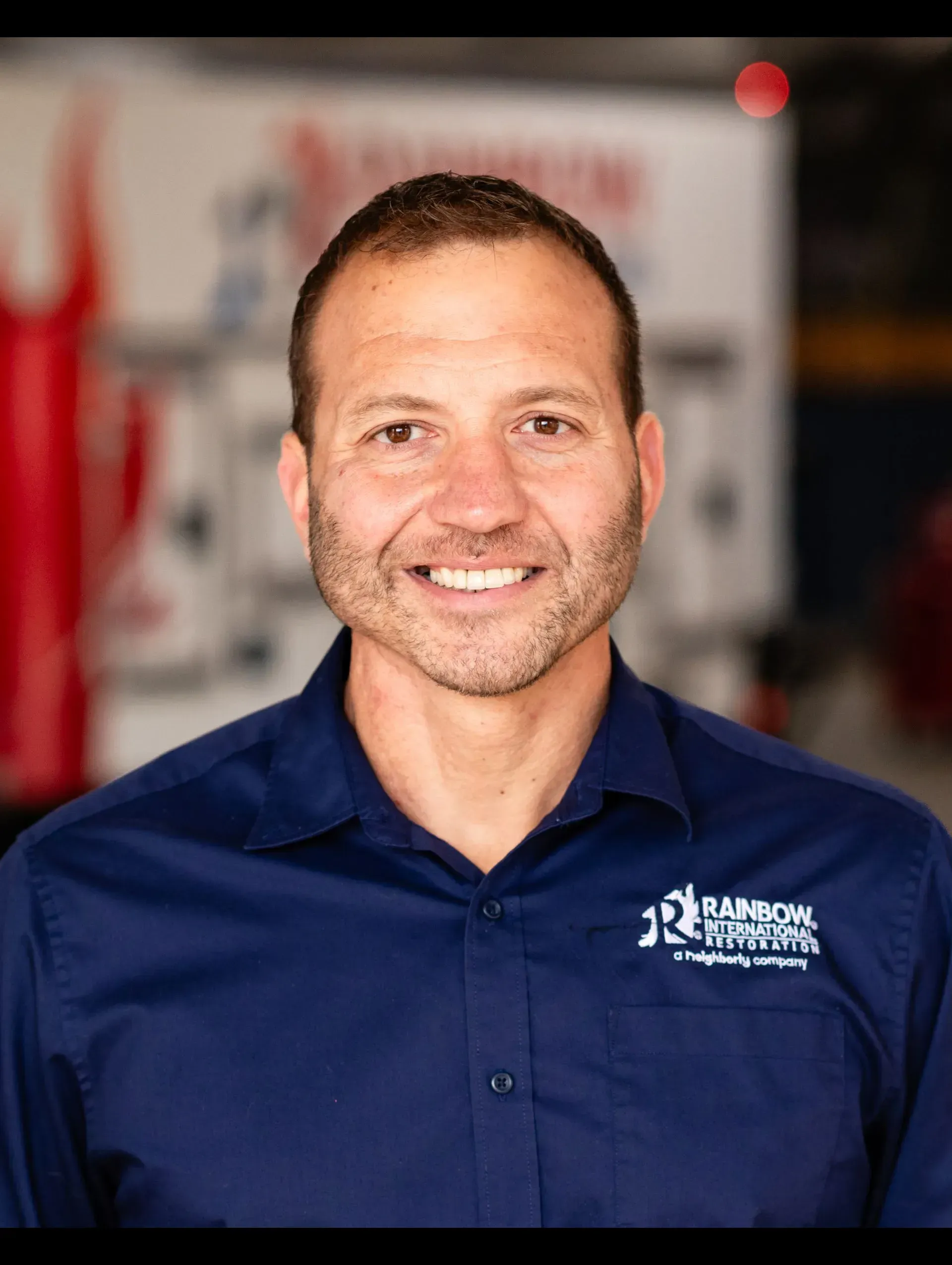 A man in a blue shirt is smiling for the camera.