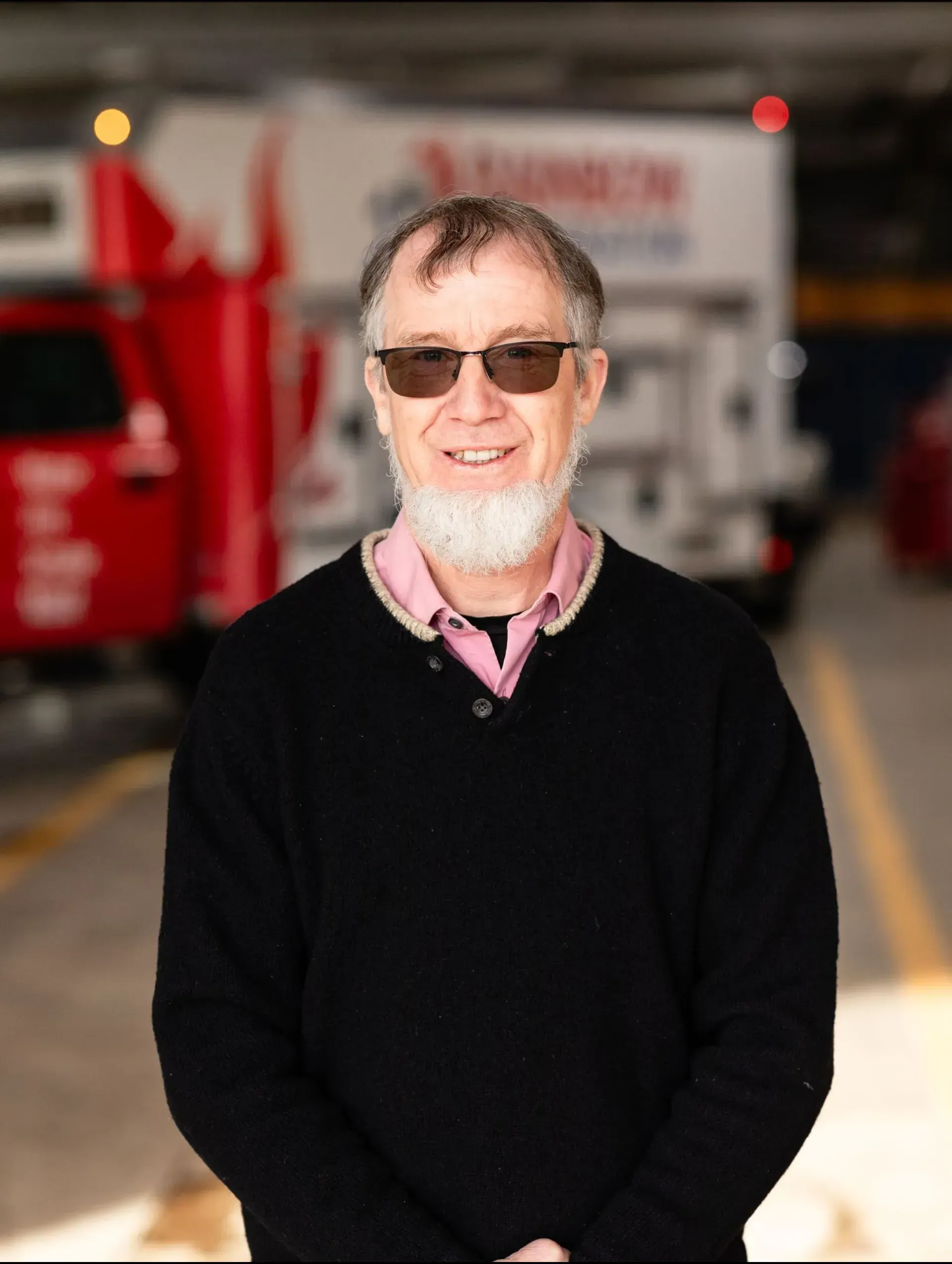 A man with a beard and sunglasses is smiling for the camera.