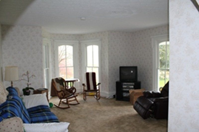 A living room with a couch and two rocking chairs.