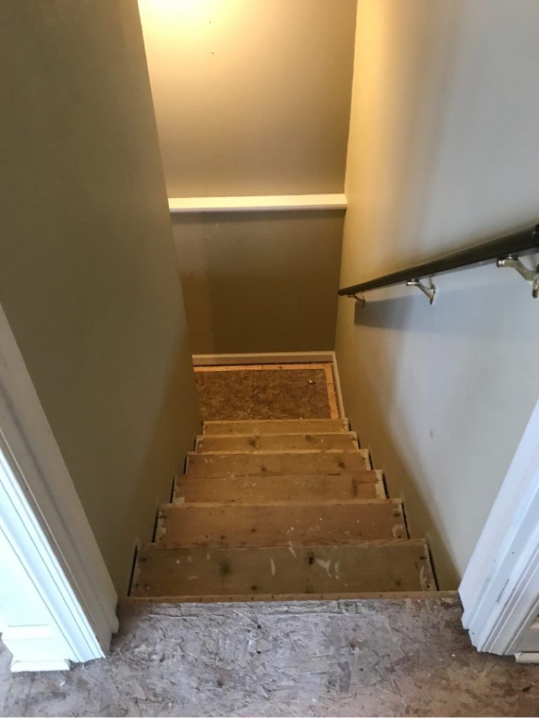 A residential wooden staircase is being repaired from water damage.
