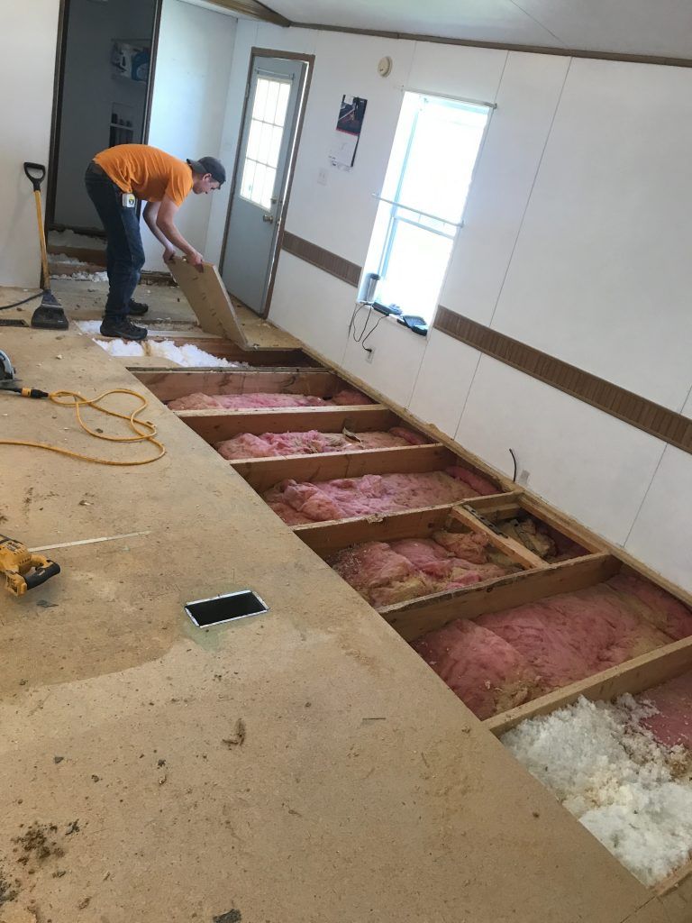 A man is working on the floor of a house.