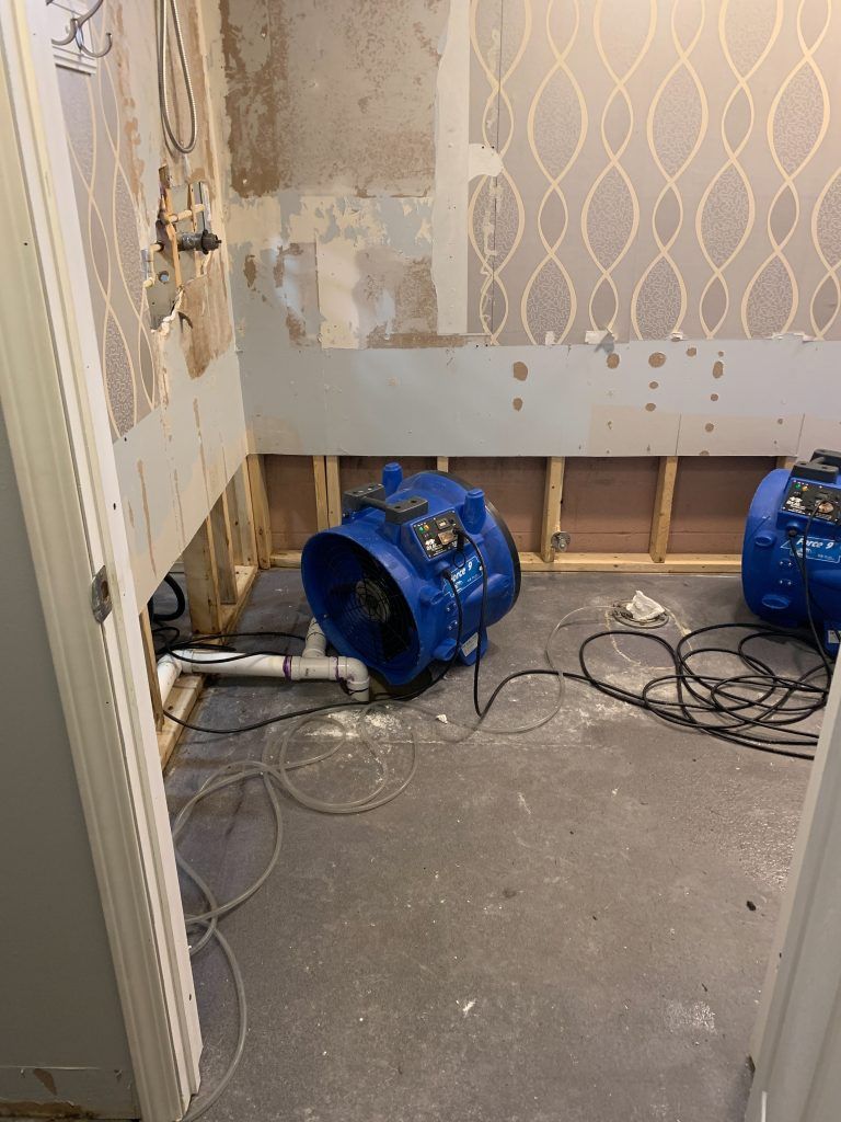 Two blue fans are sitting on the floor of a room.