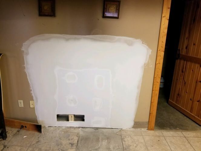 A room with a wall that is being remodeled.