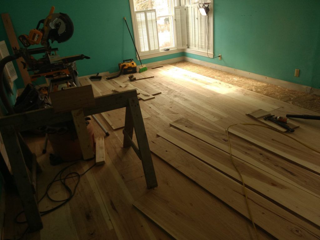 A room with wooden floors and a table with a saw on it
