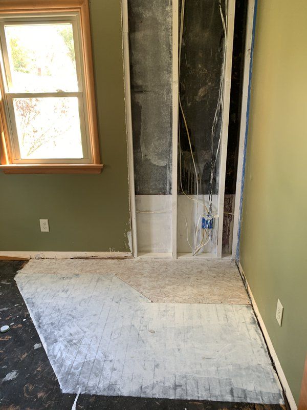 A room with a window and a door that is being fixed.