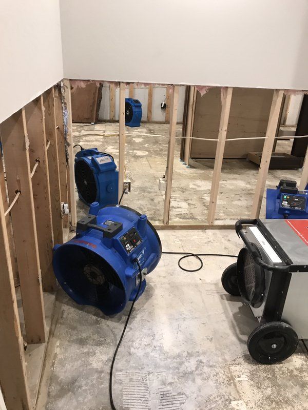 A room with industrial fans and a table in it.