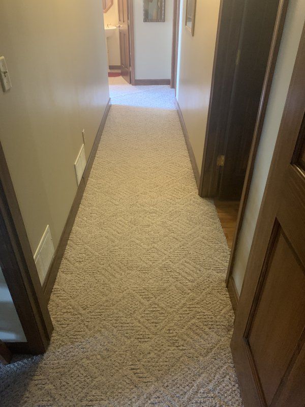 The hallway of a home with carpet.