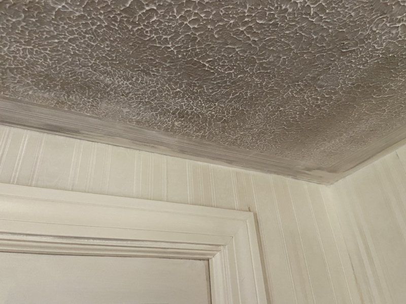 A close up of a fire-damaged ceiling in a room next to a door.