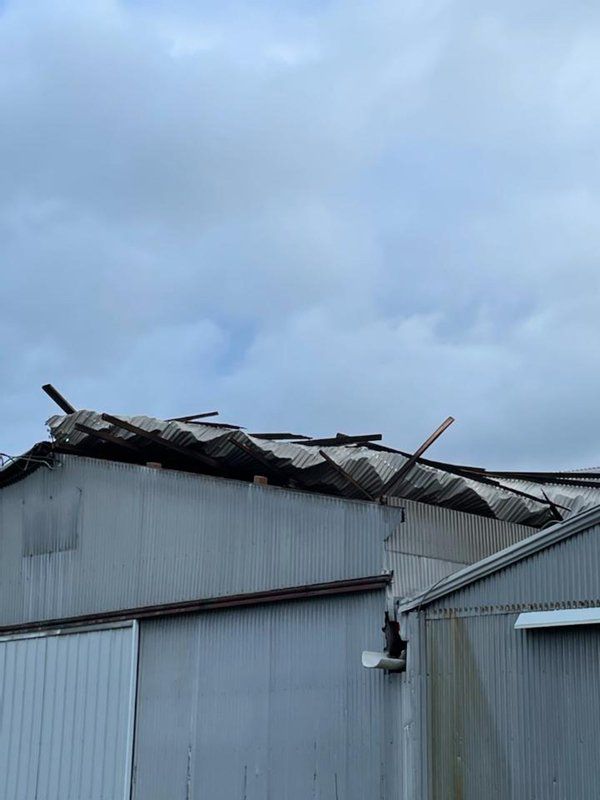 A building with a roof that has been damaged by a storm.
