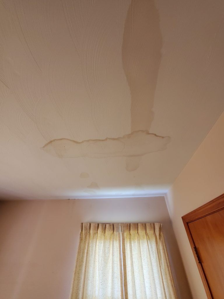 A ceiling with water damaged roof.
