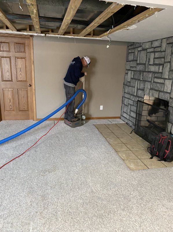 A man is cleaning a carpet in a basement t.