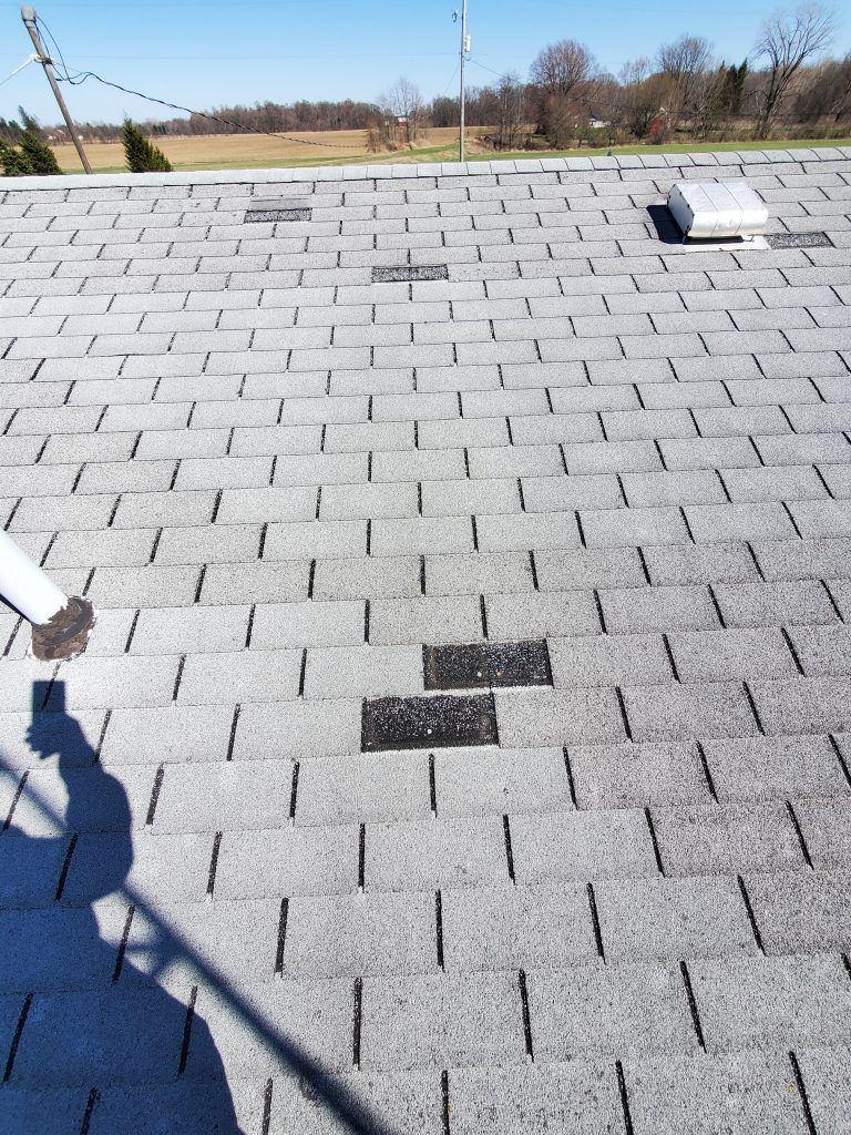 A person is standing on a roof with a shadow on it.