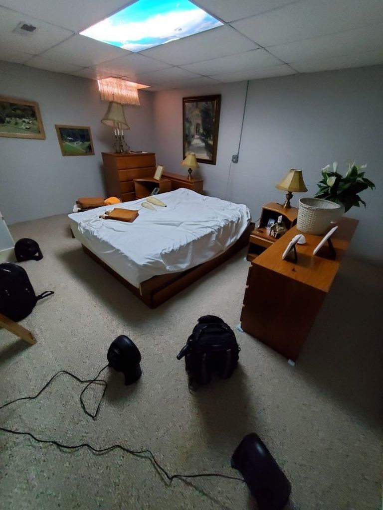A bedroom with a bed , nightstands , lamps and a picture on the wall.