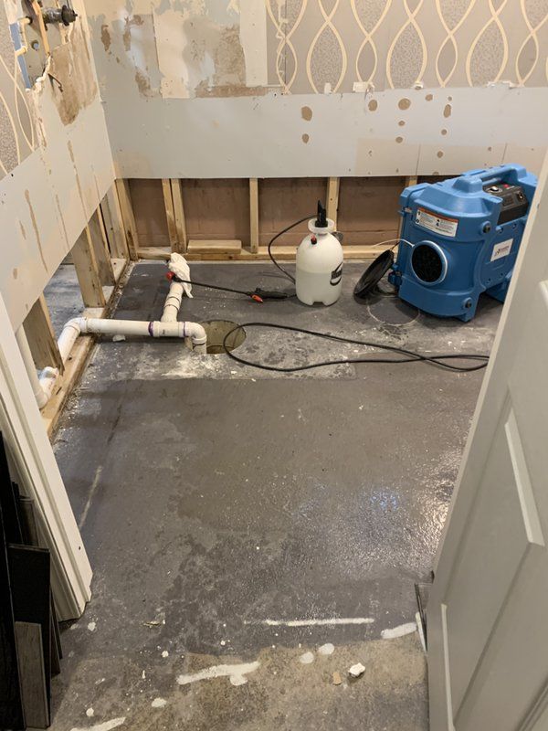 A blue vacuum cleaner is sitting on the floor of a bathroom.