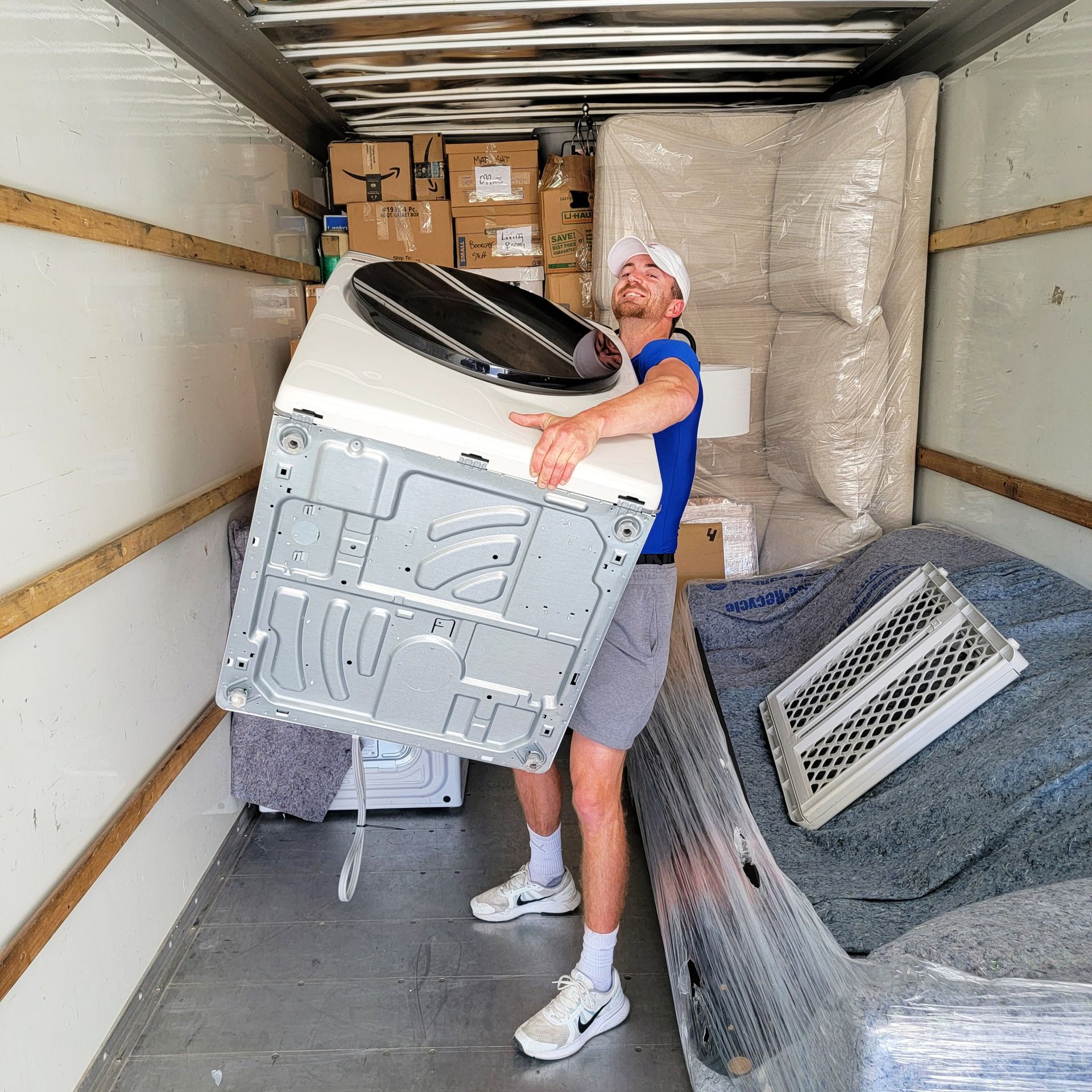 A man is carrying a washer and dryer in a moving truck - Tulsa, OK - Bison Moving